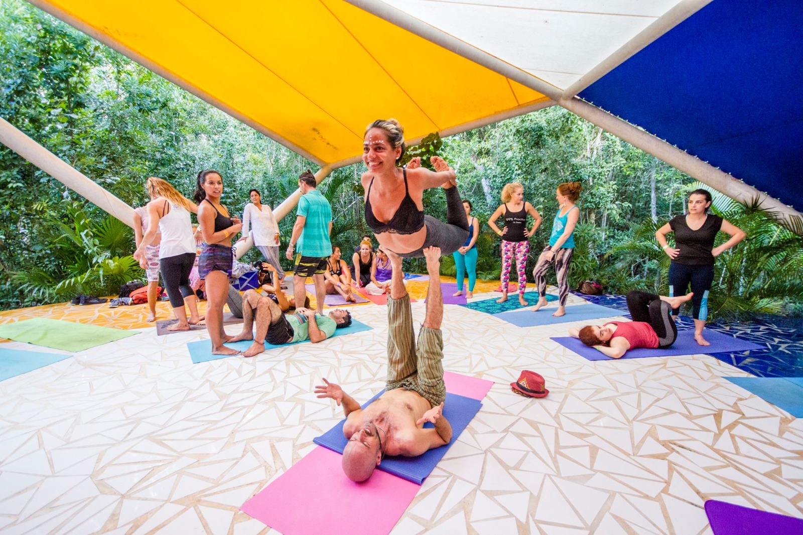 group yoga session under a colorful canopy at OZEN