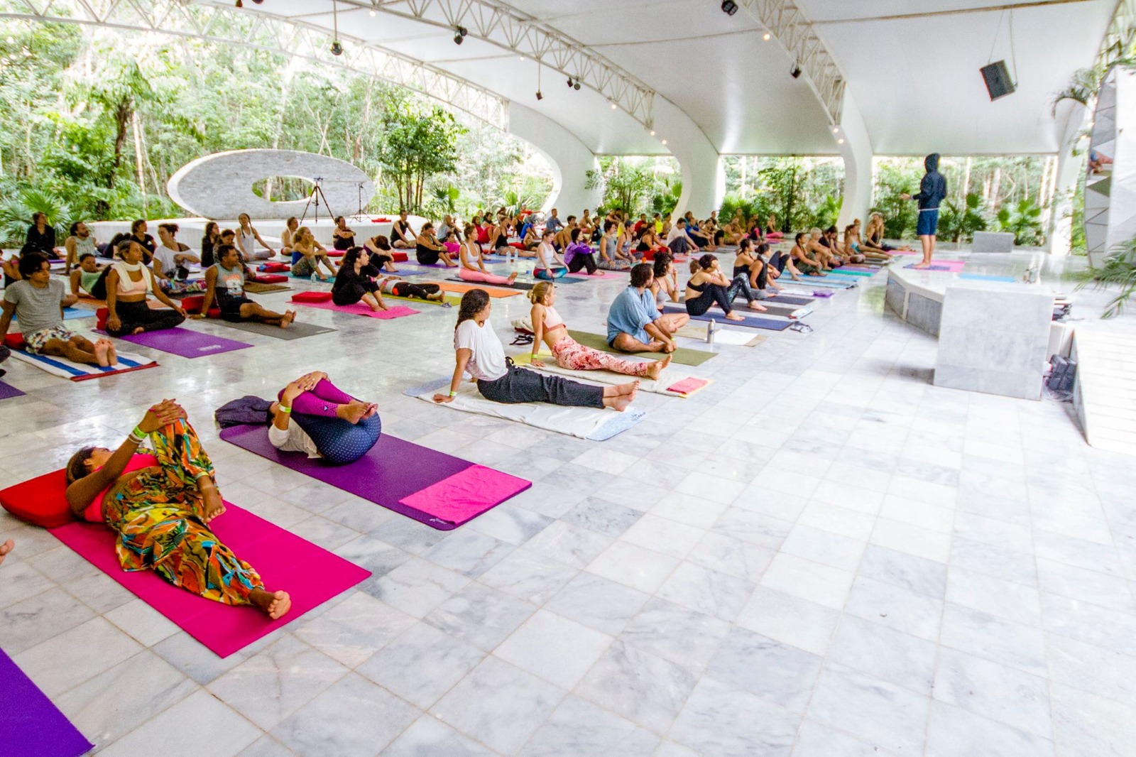 group yoga session under a colorful canopy at OZEN