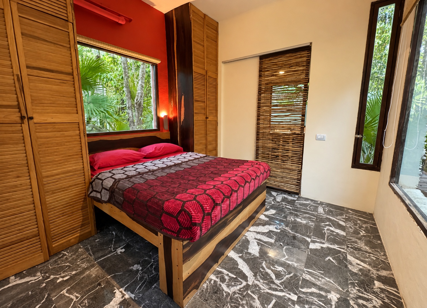 interior of a cube studio with a queen bed and forest facing window